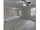 Spacious living room featuring neutral walls, ceiling fan, and access to backyard via sliding glass door at 23 Club Dr, Locust Grove, GA 30248