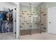 Modern bathroom featuring a glass shower with a built-in bench and open closet with clothing at 958 Austin Ne Ave, Atlanta, GA 30307