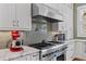 Updated kitchen features stainless steel appliances, including a professional-grade range and hood, light countertops and backsplash at 958 Austin Ne Ave, Atlanta, GA 30307