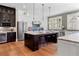 Bright kitchen boasts an island with seating, stainless steel appliances, and white and dark wood cabinets at 958 Austin Ne Ave, Atlanta, GA 30307