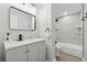Modern bathroom with gray vanity, black fixtures, and tiled shower and tub at 1277 Muirforest Dr, Stone Mountain, GA 30088