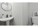 A minimalist bathroom featuring a modern round mirror and a floating sink at 1277 Muirforest Dr, Stone Mountain, GA 30088
