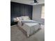 Comfortable bedroom features a dark blue accent wall, a ceiling fan, and carpeted floors at 1277 Muirforest Dr, Stone Mountain, GA 30088
