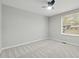 Neutral bedroom with carpet, ceiling fan, and a bright window at 1277 Muirforest Dr, Stone Mountain, GA 30088