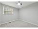 Cozy bedroom features carpet, a ceiling fan, and a bright window at 1277 Muirforest Dr, Stone Mountain, GA 30088