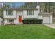 Charming home featuring a bright orange front door, complemented by freshly cut grass and a neatly maintained shrubbery at 1277 Muirforest Dr, Stone Mountain, GA 30088