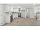An open-concept design showcases a modern kitchen featuring white cabinets and stainless steel appliances at 1277 Muirforest Dr, Stone Mountain, GA 30088