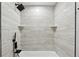 Close-up of tiled shower featuring black fixtures and corner shelves at 1277 Muirforest Dr, Stone Mountain, GA 30088