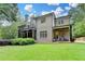Beautiful backyard with a covered patio, sunroom, and a spacious grassy area at 272 Lake Forrest Ne Ln, Atlanta, GA 30342