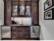 Elegant wet bar area featuring dark wood cabinetry, marble backsplash, and stainless steel beverage coolers at 272 Lake Forrest Ne Ln, Atlanta, GA 30342