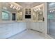 Luxurious bathroom with custom white cabinetry, marble floors, and a stunning chandelier at 272 Lake Forrest Ne Ln, Atlanta, GA 30342