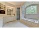 Serene bathroom with a soaking tub, a separate glass shower, and custom vanity with ample storage at 272 Lake Forrest Ne Ln, Atlanta, GA 30342