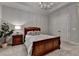 Inviting bedroom with a classic wooden bed, soft grey carpet, and elegant lighting fixture at 272 Lake Forrest Ne Ln, Atlanta, GA 30342
