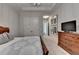 Comfortable bedroom showcasing a wooden dresser, neutral walls, and a view into an adjoining hallway at 272 Lake Forrest Ne Ln, Atlanta, GA 30342
