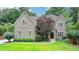 Beautiful brick home featuring a manicured lawn, mature trees, and professional landscaping at 272 Lake Forrest Ne Ln, Atlanta, GA 30342