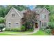Charming brick home with a landscaped front yard, arched entry, and mature trees at 272 Lake Forrest Ne Ln, Atlanta, GA 30342