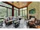 Inviting sunroom featuring brick accent wall, fireplace, cozy seating, and serene outdoor views for relaxed living at 272 Lake Forrest Ne Ln, Atlanta, GA 30342