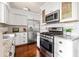 Kitchen with white cabinets, stainless steel appliances, and a stylish backsplash at 136 Peachtree Memorial Nw Dr # Nh4, Atlanta, GA 30309