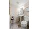 Well-lit powder room featuring a pedestal sink, decorative mirror, and stylish wood-look tile flooring at 136 Peachtree Memorial Nw Dr # Nh4, Atlanta, GA 30309
