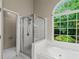 Bathroom featuring a soaking tub, separate shower, and a large window at 1694 Peachcrest Ct, Lawrenceville, GA 30043