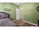 Relaxing green bedroom showcases a bed, a view to the closet, and a calm ambiance for peaceful nights at 1694 Peachcrest Ct, Lawrenceville, GA 30043