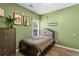 Tranquil green bedroom featuring a bed, natural light, and artistic decor for a serene and inviting retreat at 1694 Peachcrest Ct, Lawrenceville, GA 30043