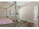 Bright bedroom featuring a wood floor, neutral walls, a white dresser and a four-poster bed with colorful patterned bedding at 1694 Peachcrest Ct, Lawrenceville, GA 30043
