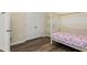 Cozy bedroom showcasing wood floors, striped accent wall, and a charming four-poster bed with colorful floral bedding at 1694 Peachcrest Ct, Lawrenceville, GA 30043