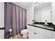 Bathroom featuring white cabinets, black countertop, and shower with stylish gray curtain at 4814 Sultana Sw Way, Atlanta, GA 30331