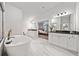 Bright bathroom featuring a soaking tub, double vanity with black countertops, and tile flooring at 4814 Sultana Sw Way, Atlanta, GA 30331