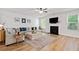 Open living room with a fireplace, ceiling fan, and large windows, creating a welcoming atmosphere at 4814 Sultana Sw Way, Atlanta, GA 30331