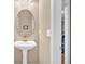 Half bath with a pedestal sink and a decorative mirror adjacent to a passageway at 4845 Backbay St, Suwanee, GA 30024