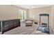 Carpeted bedroom featuring a dark wood dresser, upholstered chair, and workout equipment at 4845 Backbay St, Suwanee, GA 30024