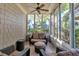 Inviting sunroom with cushioned seating, ceiling fan, and abundant natural light through large windows at 4845 Backbay St, Suwanee, GA 30024
