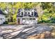 Detached three-car garage featuring carriage doors, a red entry door, and upper story windows at 965 Sundew Se Dr, Conyers, GA 30013