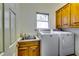 Functional laundry room with sink, washer, dryer, and overhead cabinets at 965 Sundew Se Dr, Conyers, GA 30013