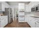 Modern kitchen with stainless steel appliances, white cabinets, and hardwood floors at 2482 Windchase Ct, Buford, GA 30518