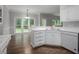 Well-lit kitchen area with stainless steel dishwasher and white cabinets, offering a view to the back yard at 2482 Windchase Ct, Buford, GA 30518
