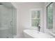 Main bathroom features a soaking tub, a glass enclosed shower, and a large window at 2482 Windchase Ct, Buford, GA 30518