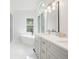 Bathroom featuring a large window over a soaking tub, a shower, and a double sink vanity at 2482 Windchase Ct, Buford, GA 30518