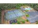 Aerial view of tennis courts, playground, and pool promising fun and community activities in a beautiful wooded setting at 2482 Windchase Ct, Buford, GA 30518