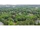 Aerial view showcases homes nestled within beautiful green trees and landscaping near a lake at 2482 Windchase Dr, Buford, GA 30518