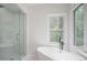 Bathroom featuring a soaking tub, seamless glass shower, and bright natural light at 2482 Windchase Dr, Buford, GA 30518