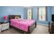Comfortable blue bedroom with a cozy bed, two windows, and a quaint nightstand at 2482 Windchase Dr, Buford, GA 30518