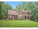 Beautiful two-story brick home with a lush green lawn and a basketball hoop at 2482 Windchase Dr, Buford, GA 30518