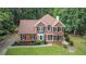 Charming two-story brick home with a well-manicured lawn and mature trees at 2482 Windchase Dr, Buford, GA 30518