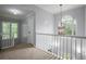 Bright hallway with chandelier lighting, complemented by white railing and view of the outdoors at 2482 Windchase Dr, Buford, GA 30518