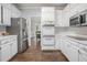 Modern white kitchen with stainless steel appliances and hardwood floors at 2482 Windchase Dr, Buford, GA 30518