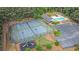 Aerial shot showcases well-maintained community tennis courts, pool, and playground in a lush, fenced setting at 2482 Windchase Dr, Buford, GA 30518