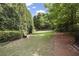 Lush backyard featuring a well-manicured lawn, mature trees, and a tranquil bench at 326 Roswell Se St # 508, Marietta, GA 30060